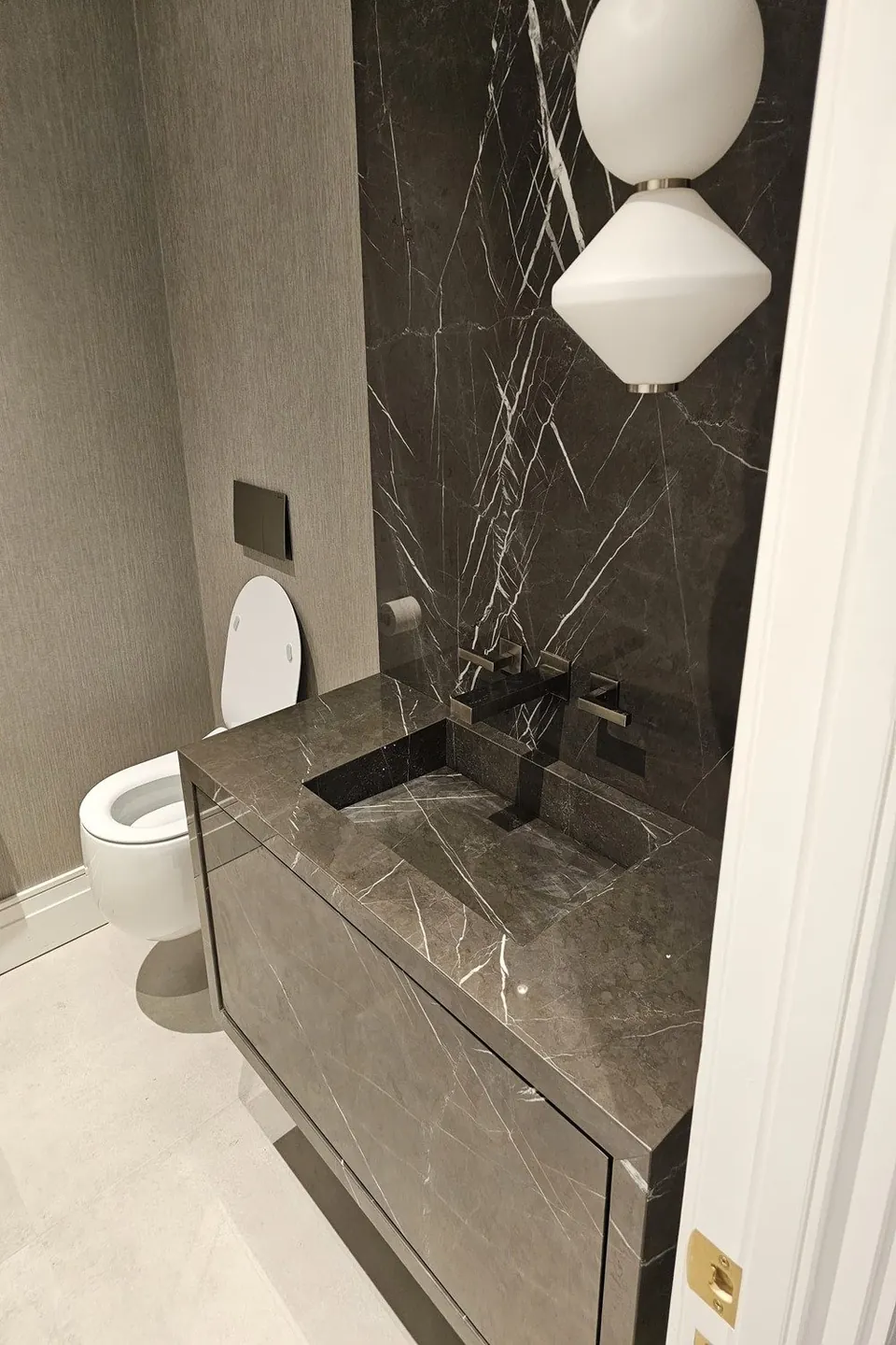 Renovated bathroom with a dark marble wall and floating vanity
