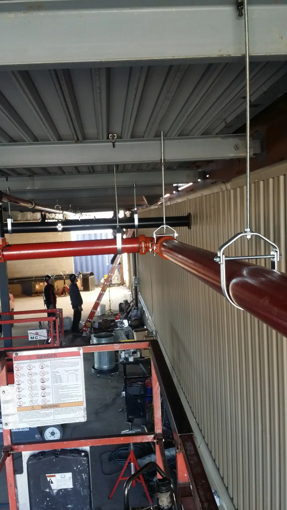 Overhead piping on hangers in a large commercial building