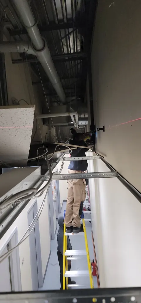 Overhead piping run along a commercial building corridor