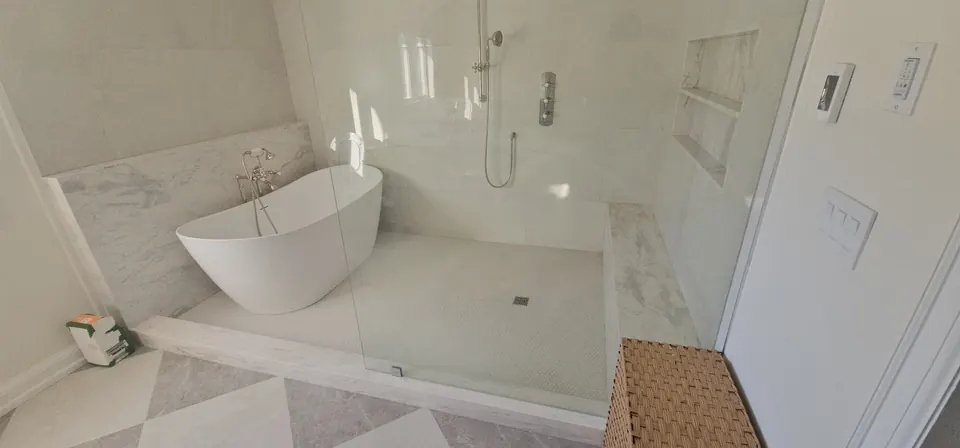 Freestanding tub beside a curbless walk-in shower