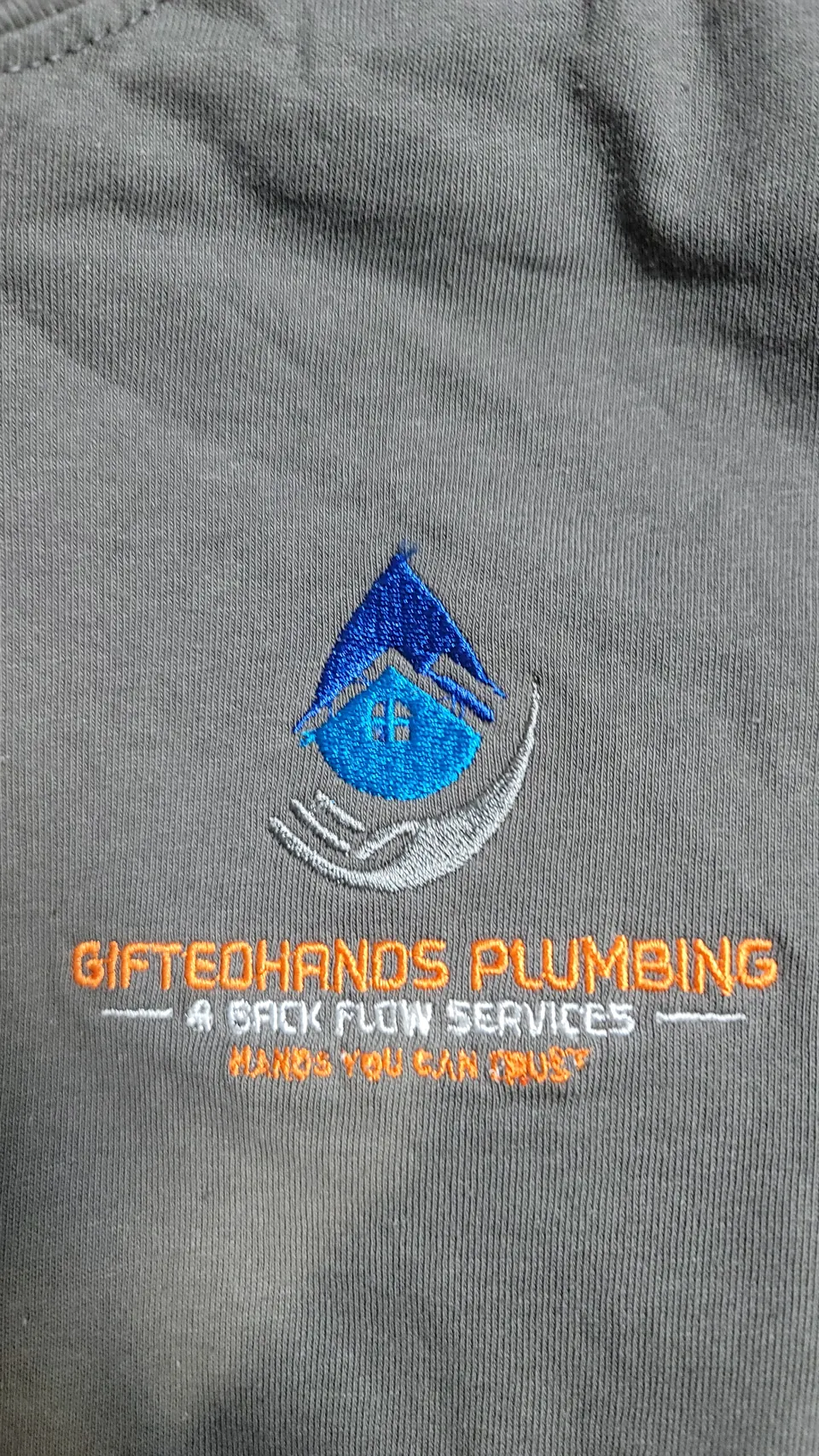 GiftedHands Plumbing logo embroidered on a crew shirt