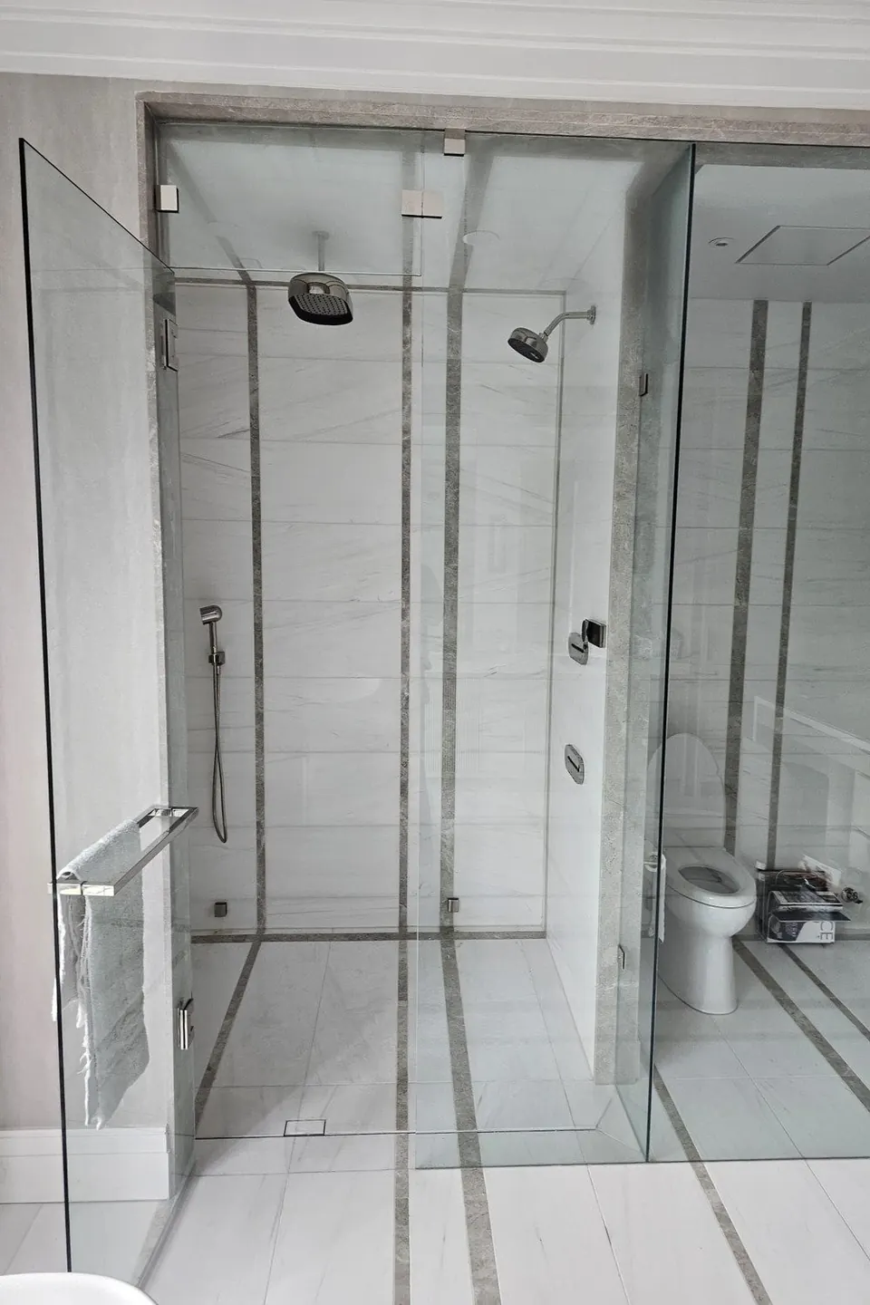 Glass walk-in shower with two shower heads after a bathroom renovation
