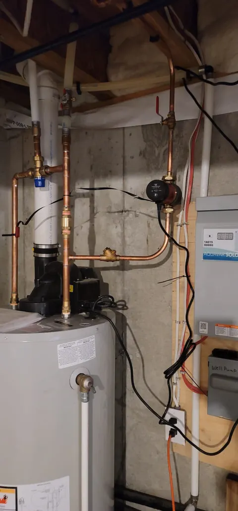 Hot water tank installed in a basement with copper connections