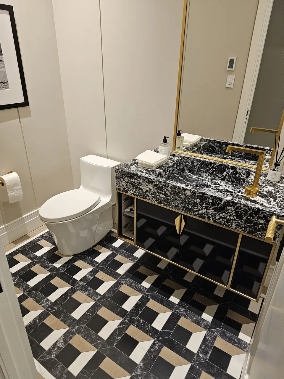 Bathroom with a marble vanity, gold fixtures and patterned tile