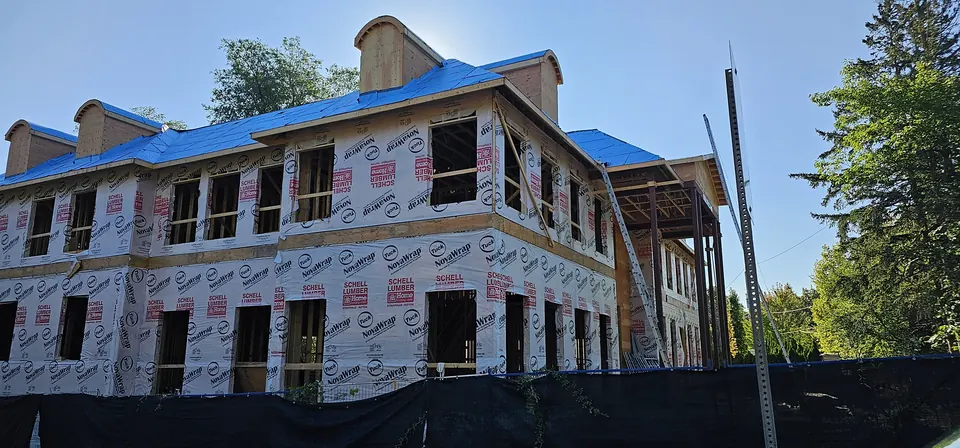 Three-storey multi-unit building under construction in house wrap