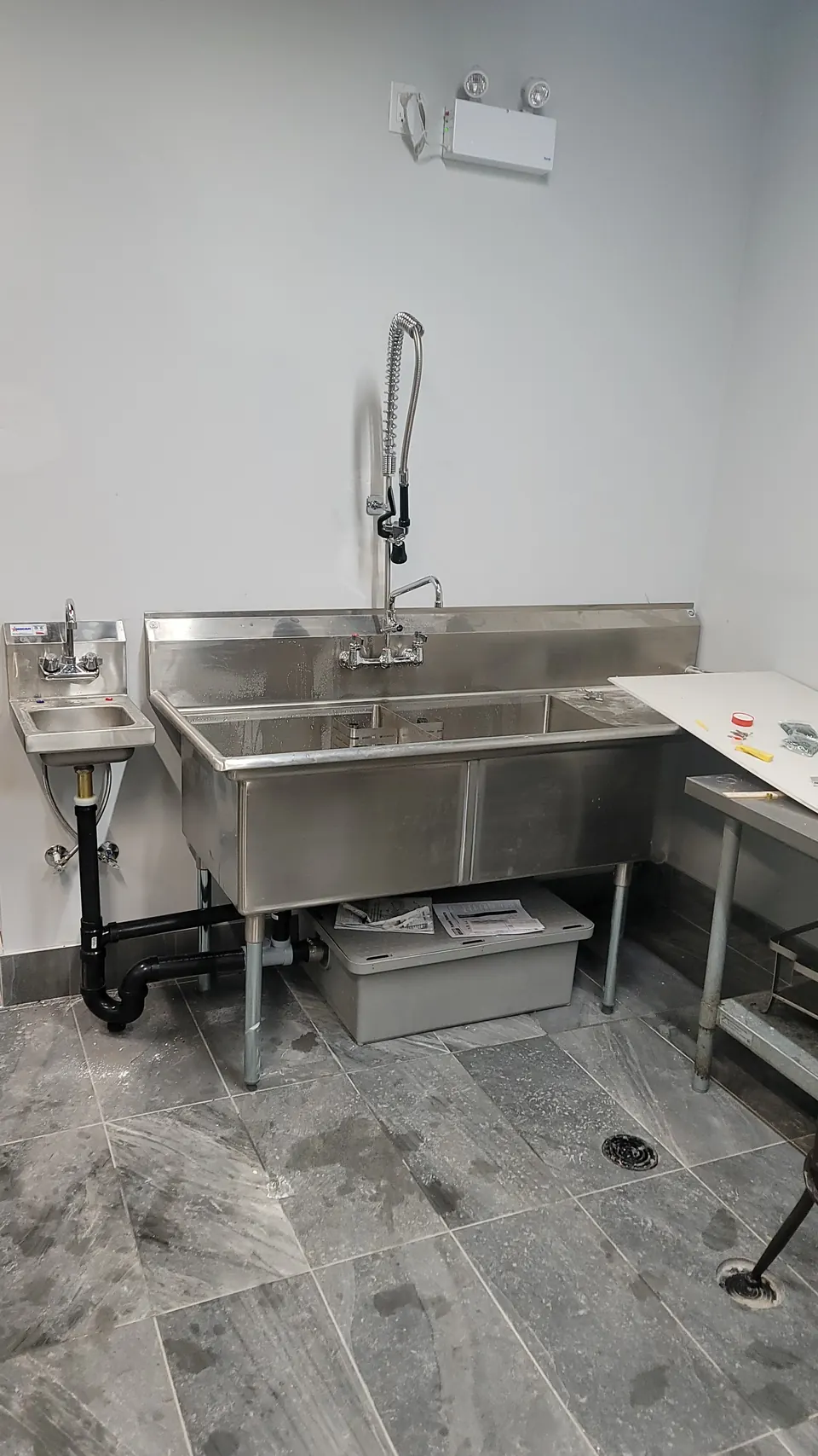Stainless three-compartment sink and hand sink installed in a restaurant